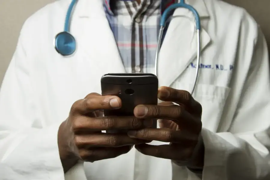 Medic analizând datele pacientului pe o tabletă într-un cabinet clinic